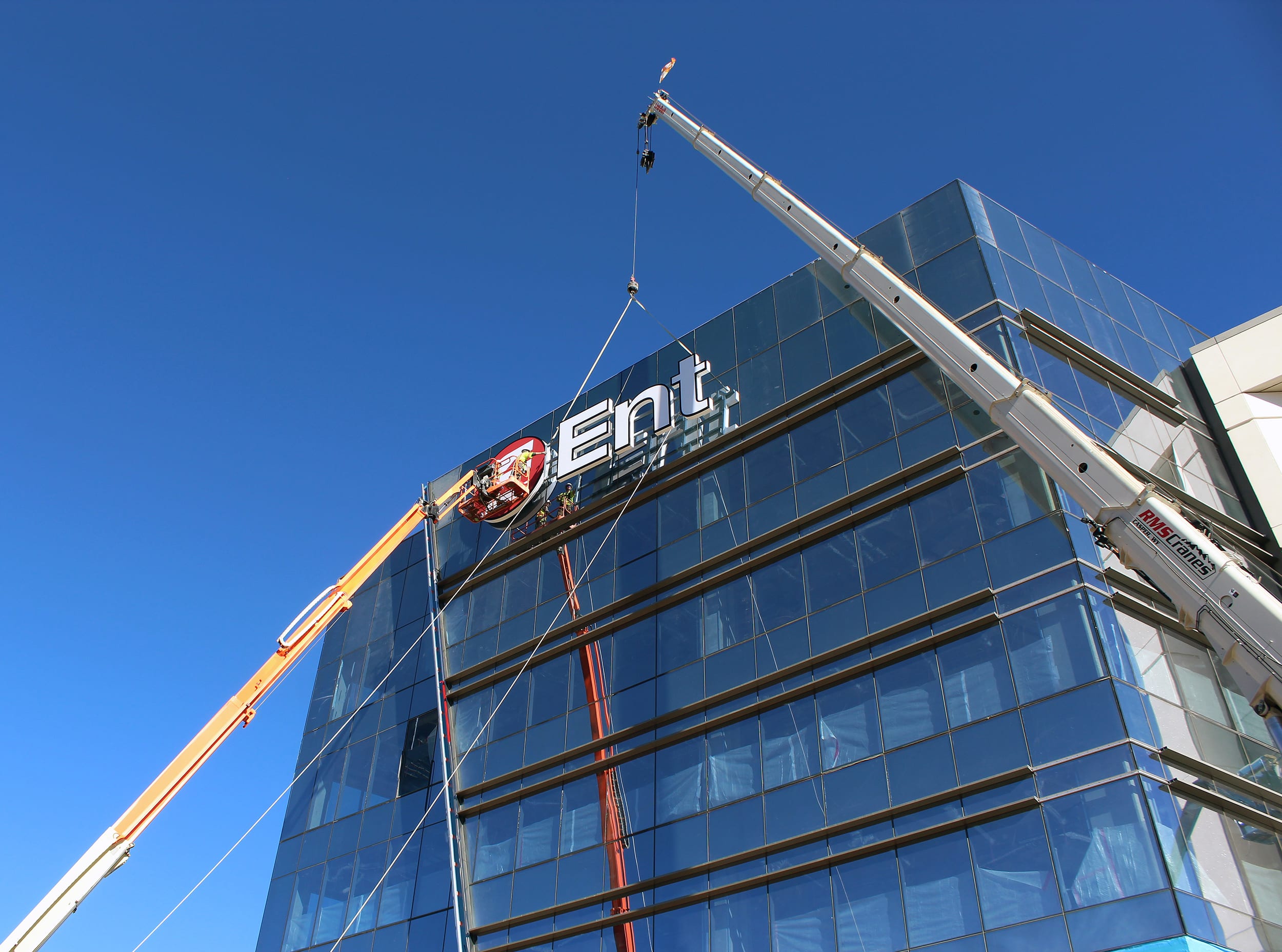 This install by Sign Shop Illuminated was unique as the sign had to be installed on the windows and required specific anchoring points and custom bracketing. Due to the height, additional cranes and a lift plan were critical.