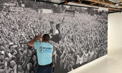 Gabe Chavez, one of two Screaming Images installers, smoothing out a wallcovering for the just-opened Punk Rock Museum in Las Vegas.